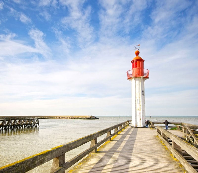 Phare rouge et blanc sur un quai en bois