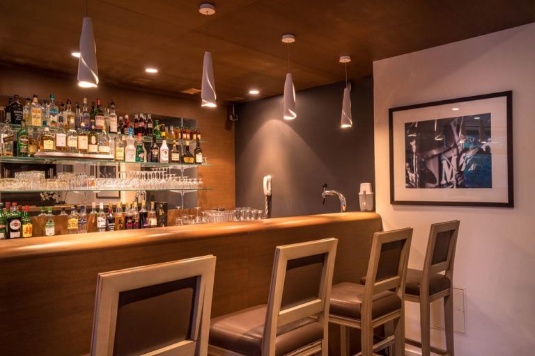 Bar moderne avec éclairage suspendu et tabourets élégants
