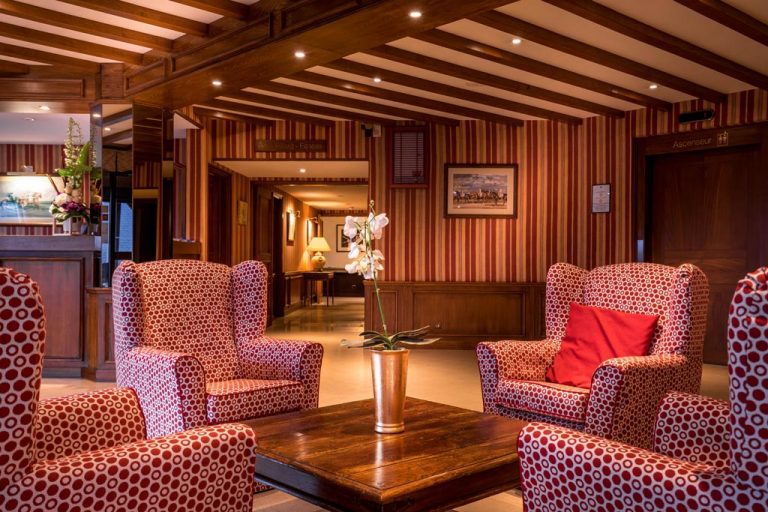 Salon d'hôtel élégant avec fauteuils rouges et boiseries