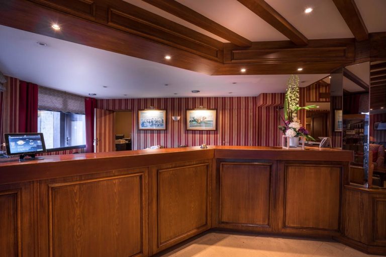 Réception hôtel élégante avec bois et rideaux rouges