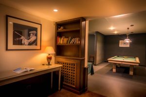 Salle de jeu avec billard et bibliothèque éclairée