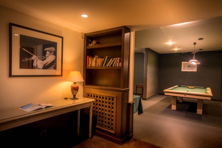 Salle de jeu avec billard et bibliothèque éclairée