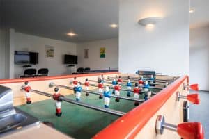 Salle de jeux avec baby-foot et télévisions murales