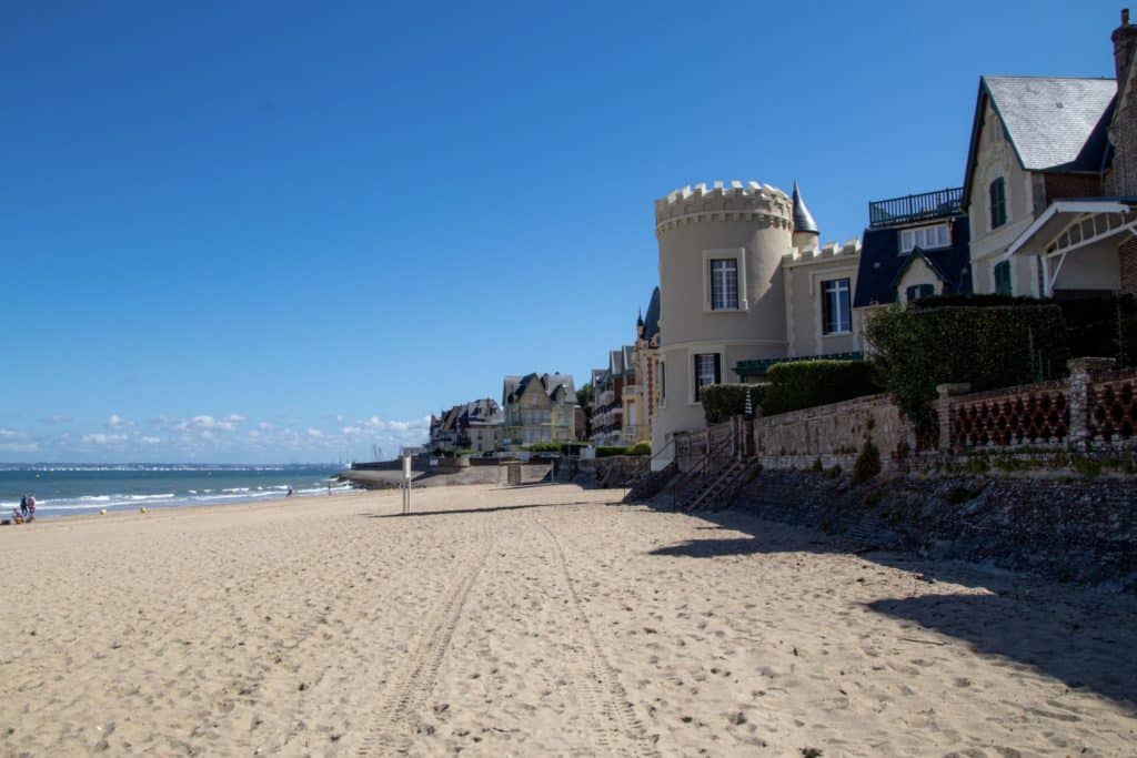 Plage française avec maisons traditionnelles sous ciel bleu