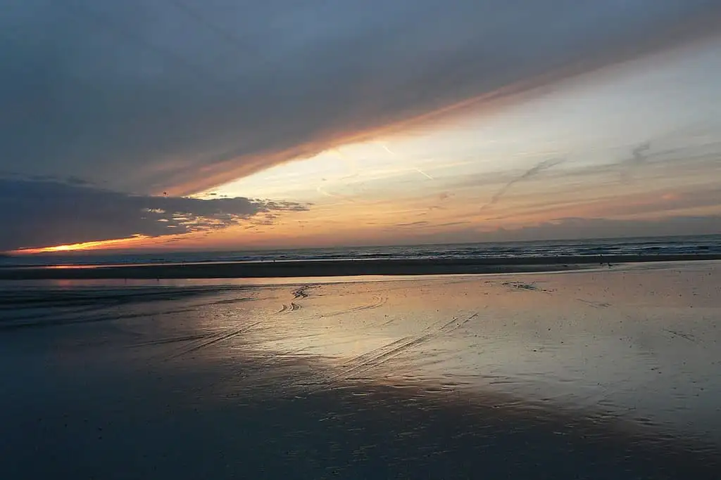 Coucher de soleil reflétant sur une plage tranquille